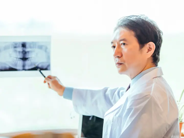 レントゲン写真を指しながら説明する医師