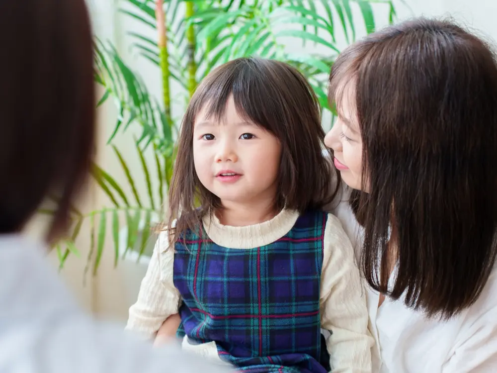 母親に寄り添われて笑う女の子